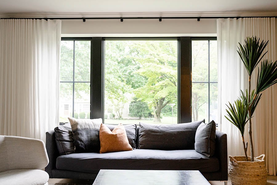 Living room with Andersen 400 Series casement windows with colonial grilles that suits the Cape Cod’s style